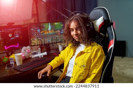 Teenage girl playing video games and sits in hi -tech room with modern computer and big monitors. Closeup. Royalty-Free Stock Photo #2244837911