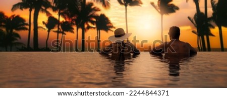 couple enjoying sunset from infinity pool at tropical Bali island resort hotel. romantic beach getaway holiday. banner with copy space