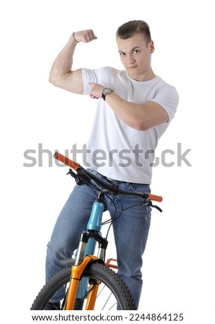 Handsome young man posing with a blue and orange modern bicycle and pointing to his piceps muscle isolated on white background