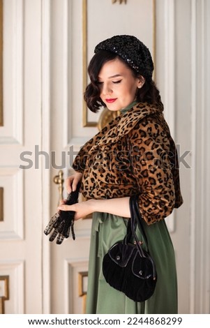 beautiful and happy brunette in retro clothes, beret and with a handbag. the concept of the stylist's work. thematic photo shoot.