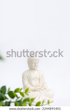 Vertical banner for Vesak Day. Happy Buddha Day with Siddhartha Gautama statue on white background. Mental health and meditation concept. Selective soft focus.