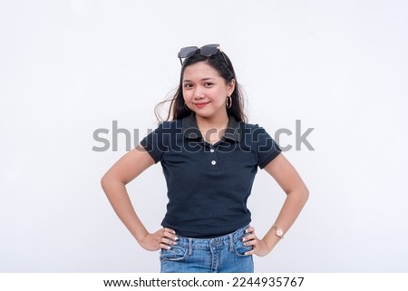 A pretty young asian lady in a dark blue polo shirt and jeans. Isolated on a white background.
