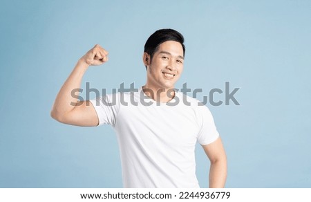 Asian male portrait posing on blue background Royalty-Free Stock Photo #2244936779