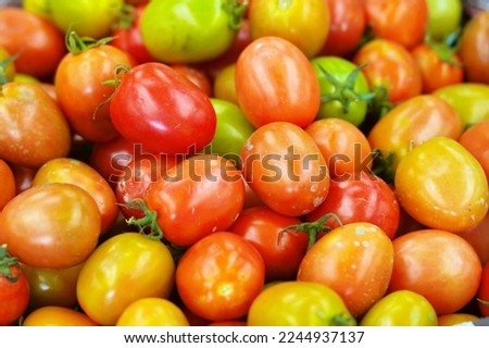 Tomatoes, yellow-orange colors piled up for sale in the market.