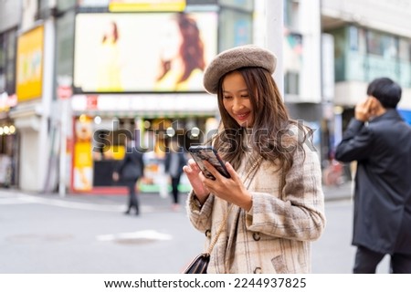 Asian woman friends using mobile phone taking selfie while travel and shopping at Shibuya, Tokyo, Japan. Attractive girl enjoy and fun outdoor lifestyle travel city street on autumn holiday vacation.