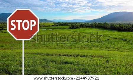 Roadside stop sign in the outdoors with lush pastures in the background