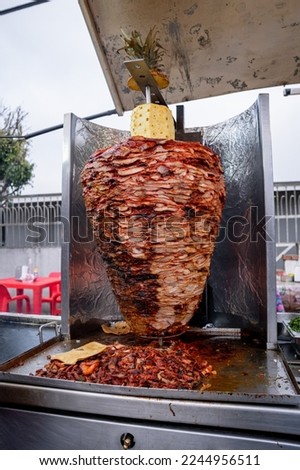 Mexican al pastor style meat, grilled, at a taco stand on the street.