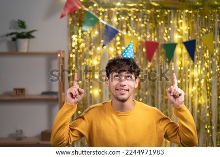 Arabic positive guy promoter point index fingers copy space suggest select adverts promotion wear stylish clothing, celebrating birthday at home b-day party. Copy space