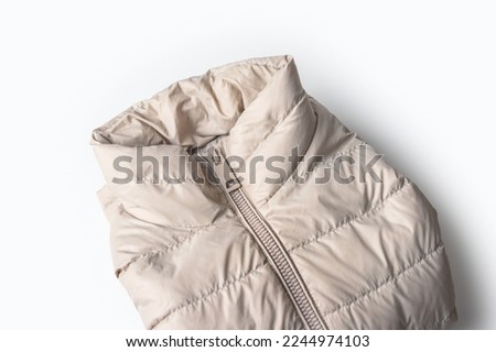 Beige padded coat zipper ,down jacket, rain proof winter jacket on white background.Top view Royalty-Free Stock Photo #2244974103