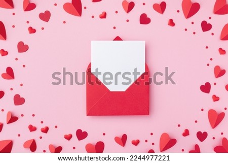 Valentine day background with envelope, paper card and various red hearts for love romantic message. Flat lay composition.
