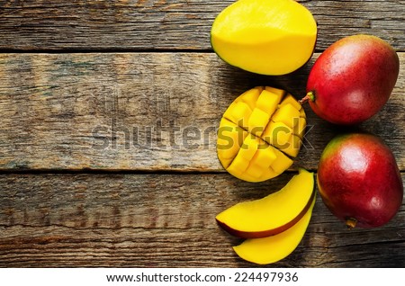 mango on a dark wood background. tinting. selective focus on the mangos slices Royalty-Free Stock Photo #224497936