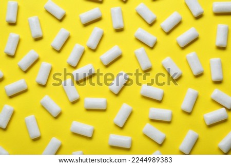Tasty white chewing gums on yellow background, flat lay Royalty-Free Stock Photo #2244989383