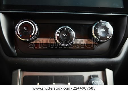 The process of choosing climate control in the car. Man regulating temperature on car air condition. Modern car interior