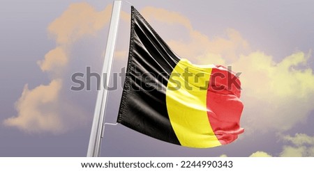 Waving Flag of Belgium in the Sky. The symbol of the state on wavy cotton fabric.