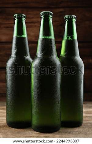 Many bottles of beer on wooden table, closeup