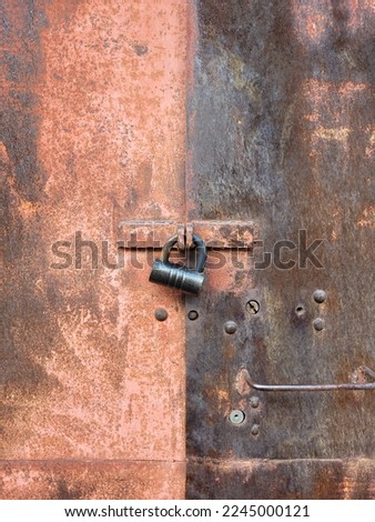 Padlock on old rusty door. Metal garage doors with copy space.