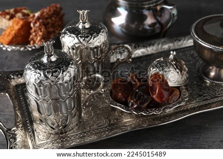 Tea, Turkish delight and date fruits served in vintage tea set on grey textured table