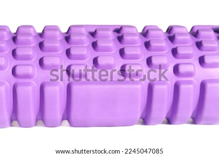 A purple foam massage roller isolated on a white background. Foam rolling is a self myofascial release technique. Gym fitness equipment.	