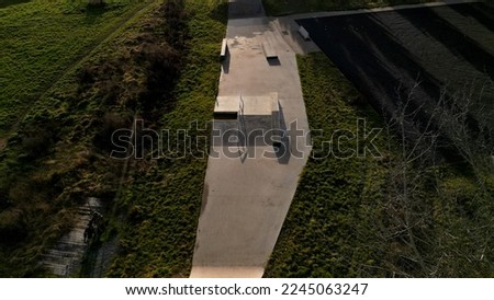Skateboard park with concrete cement surface with concrete skateboard obstacles is designed for roller sports. Cycling is not allowed except for freestyle bikes.  winter morning sunrise, above, high