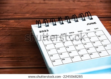 June 2023 white desk calendar on wooden table background. Royalty-Free Stock Photo #2245068285