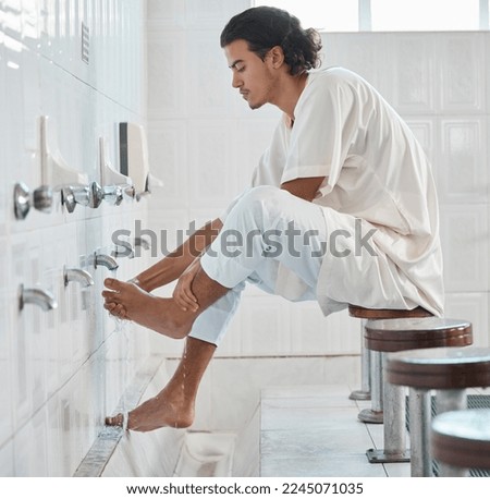Muslim, water and man cleaning feet for ablution, wudu or spiritual purification hygiene for Islamic religion, worship or moslem culture. Indonesia mosque, Islam faith and profile of man washing foot Royalty-Free Stock Photo #2245071035