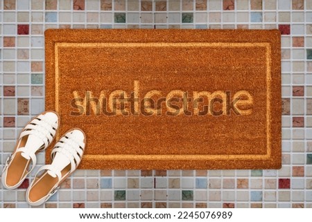 Designer Welcome Entry Doormat Placed on Square Marble Floor with White Ladies Sandles