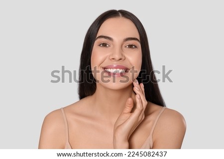 Portrait of attractive young woman on light grey background. Spa treatment