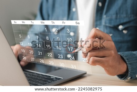 Businessman manages time for effective work. Calendar on the virtual screen interface. Highlight appointment reminders and meeting agenda on the calendar. Time management concept. Royalty-Free Stock Photo #2245082975