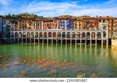Basque country. Embankment of the Oria River. Beautiful  bridge was built across the river. The picturesque center of Tolosa is built on the banks of the Oria River.  Royalty-Free Stock Photo #2245085887