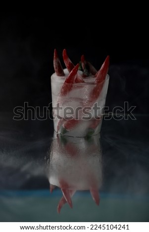 a lot of red hot chili peppers frozen in a piece of ice and thick smoke around on a black and mirror background. for splash screens labels banners business cards menu signs