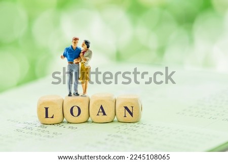 Benefits of personal loan for newly married couple, financial planning concept : Loving couple embraces on wood cubes with the word LOAN on a bank statement. Newlyweds think about buying a new house. Royalty-Free Stock Photo #2245108065