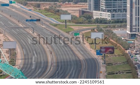 Aerial view of Al Khail road busy traffic near business bay district timelapse. Green lawn and bicycle path