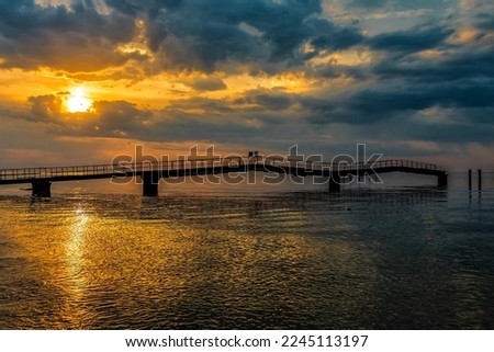 Old ruined pier at beautiful cloudy sunset on the Kinburn spit. Ukraine