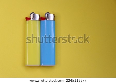 multi-colored lighters on a yellow background