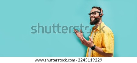 Call center operator, online store service manager wears headphones speaks into microphone answers call, leads negotiations advises online sales. Isolated on blue background Royalty-Free Stock Photo #2245119229