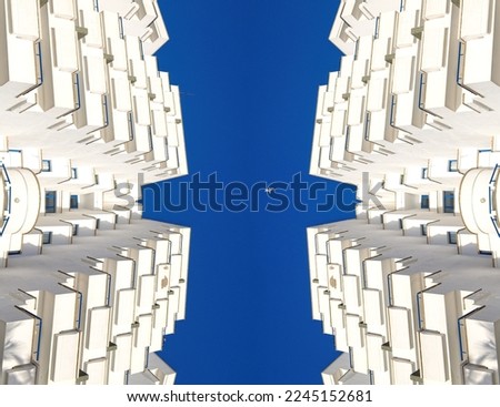 Artistic photo of block appartments and white seagull in the blue sky, view up