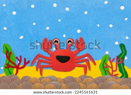 red crab made from plasticine on colorful under water background