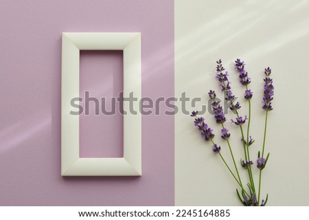 Mockup with white blank frame on gentle violet   background  with lavender flowers