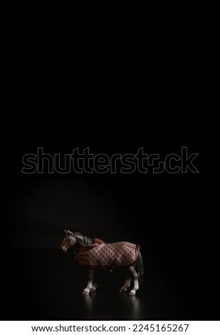 Black toy horse isolated on black background