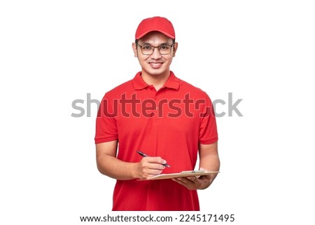 Young smiling asian delivery man in red uniform and cap holding clip board standing on isolated white background. Royalty-Free Stock Photo #2245171495