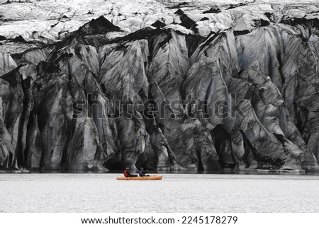 yellow kayak or canoe in a glacier lagoon in front of the dark ice wall. Picture looks like paintet