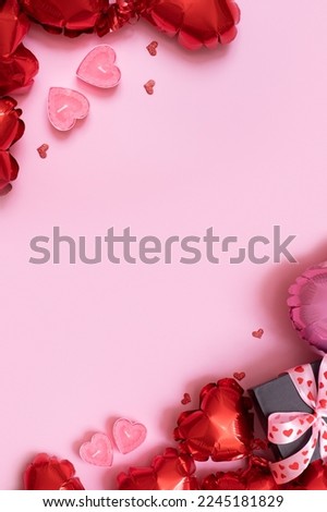 Valentines Day banner background with copy space and gift box, candels and red heart shape balloons on pink background.