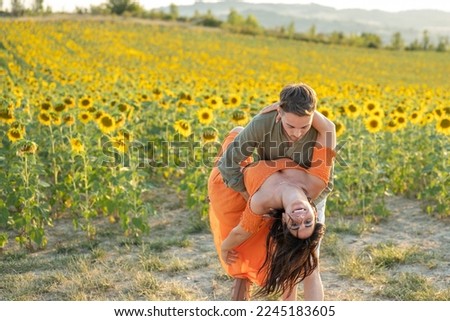 Young couple of lovers dancing outdoors in a field of sunflowers, be my valentine concept Royalty-Free Stock Photo #2245183605