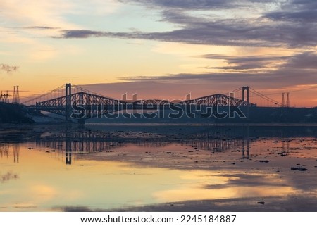 The Pierre-Laporte and Quebec bridges in silhouette during a pink and orange winter sunrise on the St. Lawrence River, Cap-Rouge area, Quebec City, Quebec, Canada Royalty-Free Stock Photo #2245184887