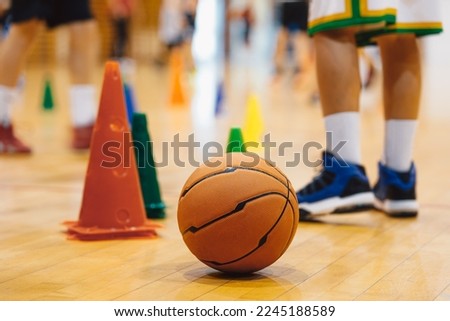 Junior basketball training. Boys practicing basketball on training session. Basketball on wooden floor on court