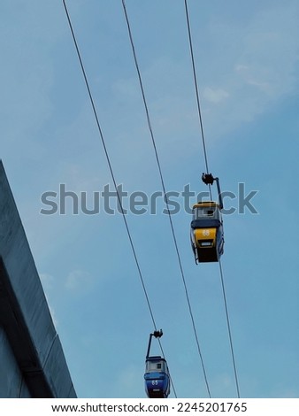 two electric cars overhead during the day, photo taken from below