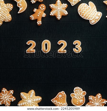 Cozy Christmas gingerbread set frame on a black background and the number 2023 in the Center. Top View. Christmas and a Happy New Year Concept. Square Format