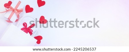 Congratulatory banner with hearts, white gift boxes tied with red and pink ribbons. Top view of valentines day gifts. Copyspace. Flat lay, top view