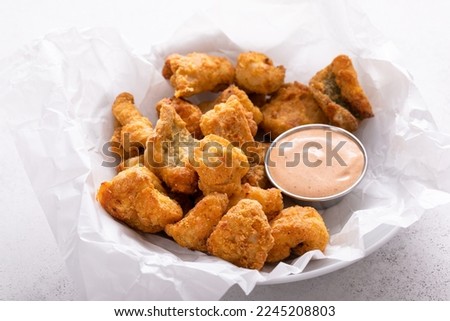 Fried catfish nuggets served with remoulade sauce on a plate with parchment paper Royalty-Free Stock Photo #2245208803