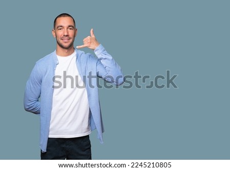 Happy young man making a gesture of calling with the hand